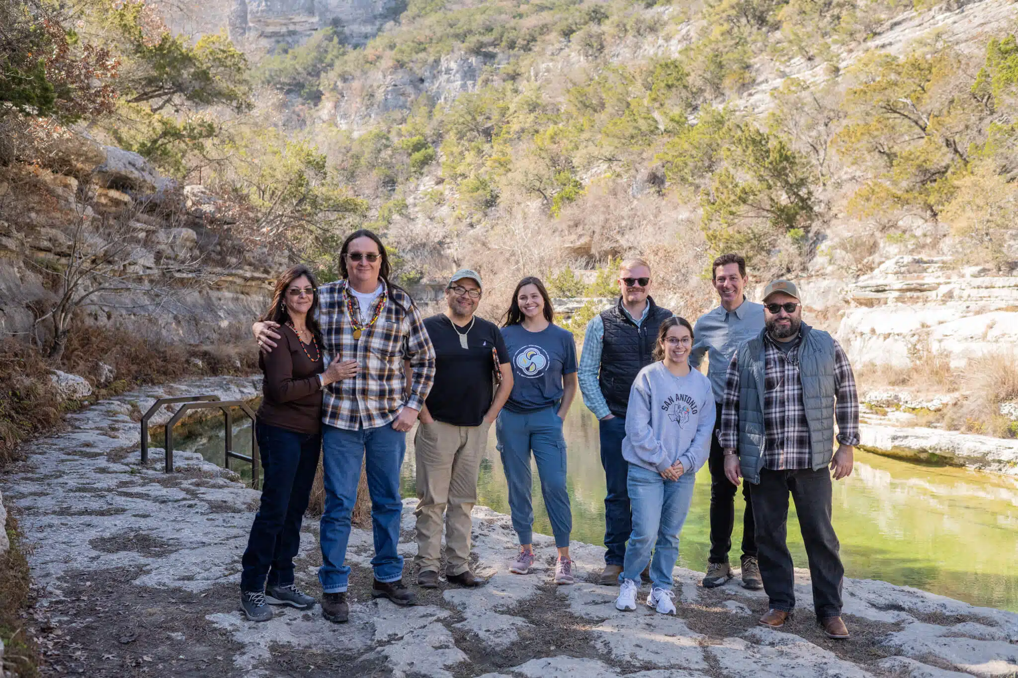8 people standing next to the Frio River.